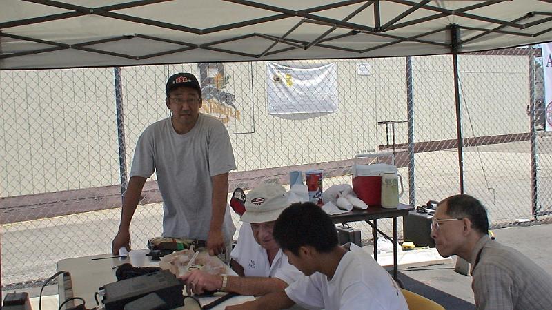 DSC04775.JPG - Curtis Watanabe KI6KUK standing, Mel Hughes K6SY operating at Get On the Air (GOTA) station, Christopher Sue KI6DDJ (Scout Troop 586), and Scout Troop visitor
