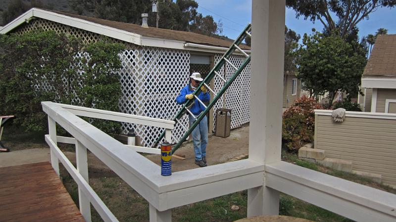 IMG_0178.JPG - WD-40 does the job to disassemble the tri-band beam;  W6HIP carries the ladder