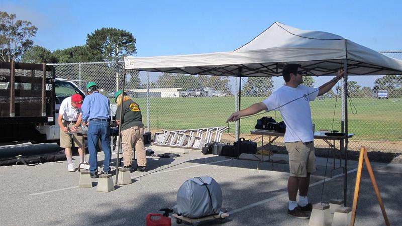 021.JPG - Tony, KK6DYL, finishes assembling canopy for VHF/UHF station as Mel, Cindy, and Gary work on antenna.