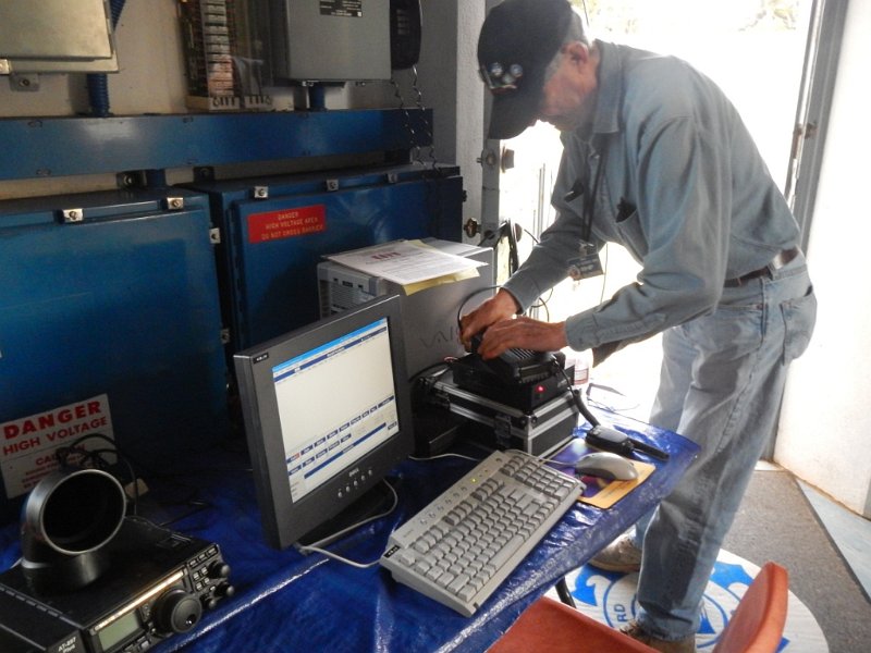 DFSu059a.jpg - Bob W6HIP reconnects all cables to begin Sunday operation. Note audio enhancement pipe atop the Yaesu FT-897 speaker.